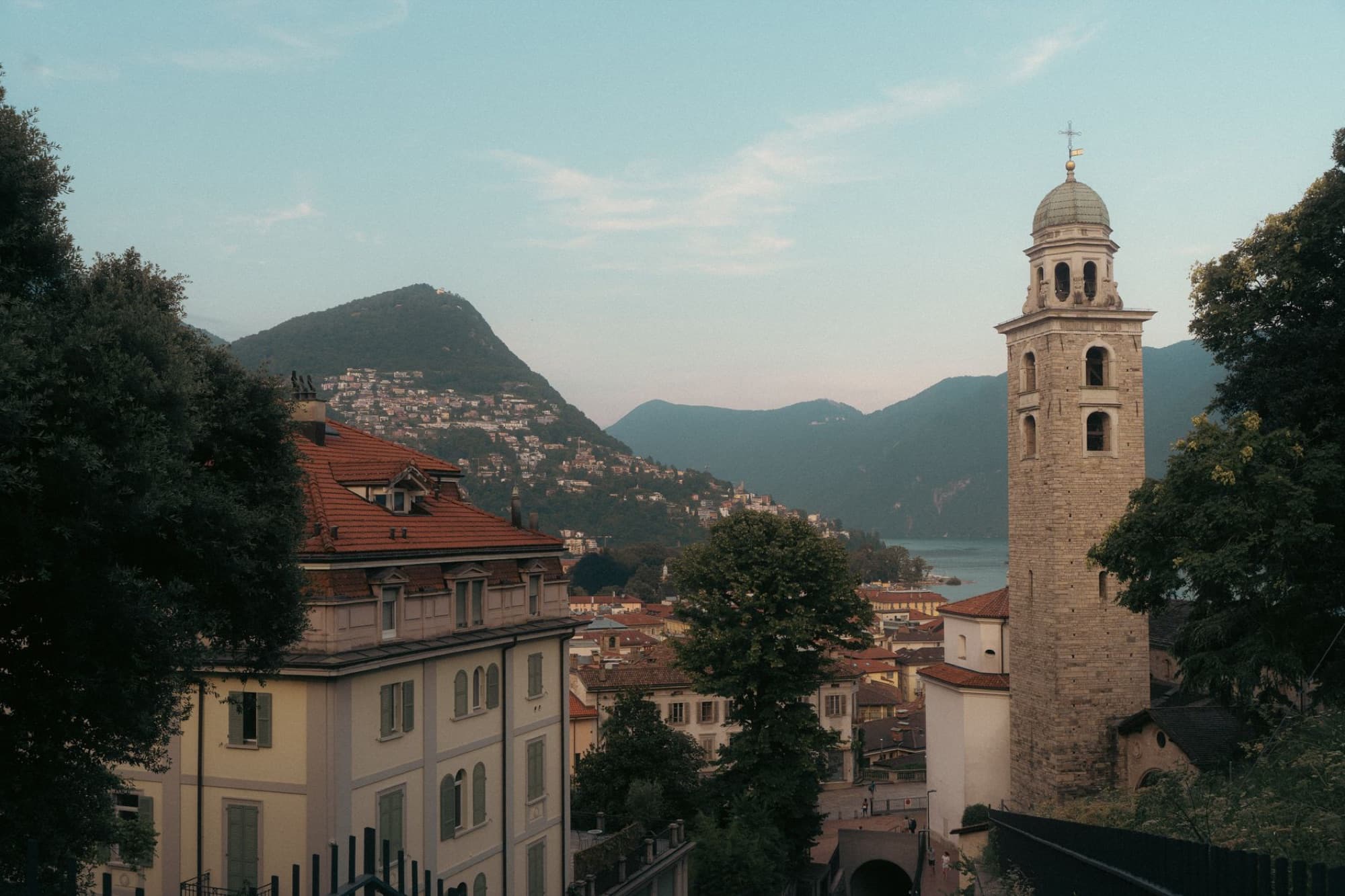 Charming landscape featuring a historic bell tower and mountains in the picturesque region of Ticino, Switzerland.