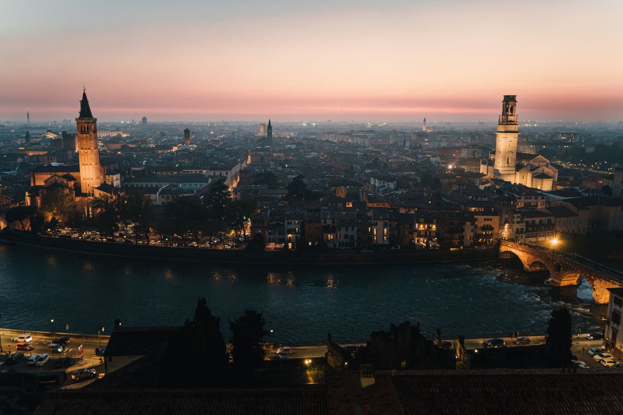 Stunning view of Verona, Italy's skyline at sunset, showcasing historic architecture and the tranquil river.